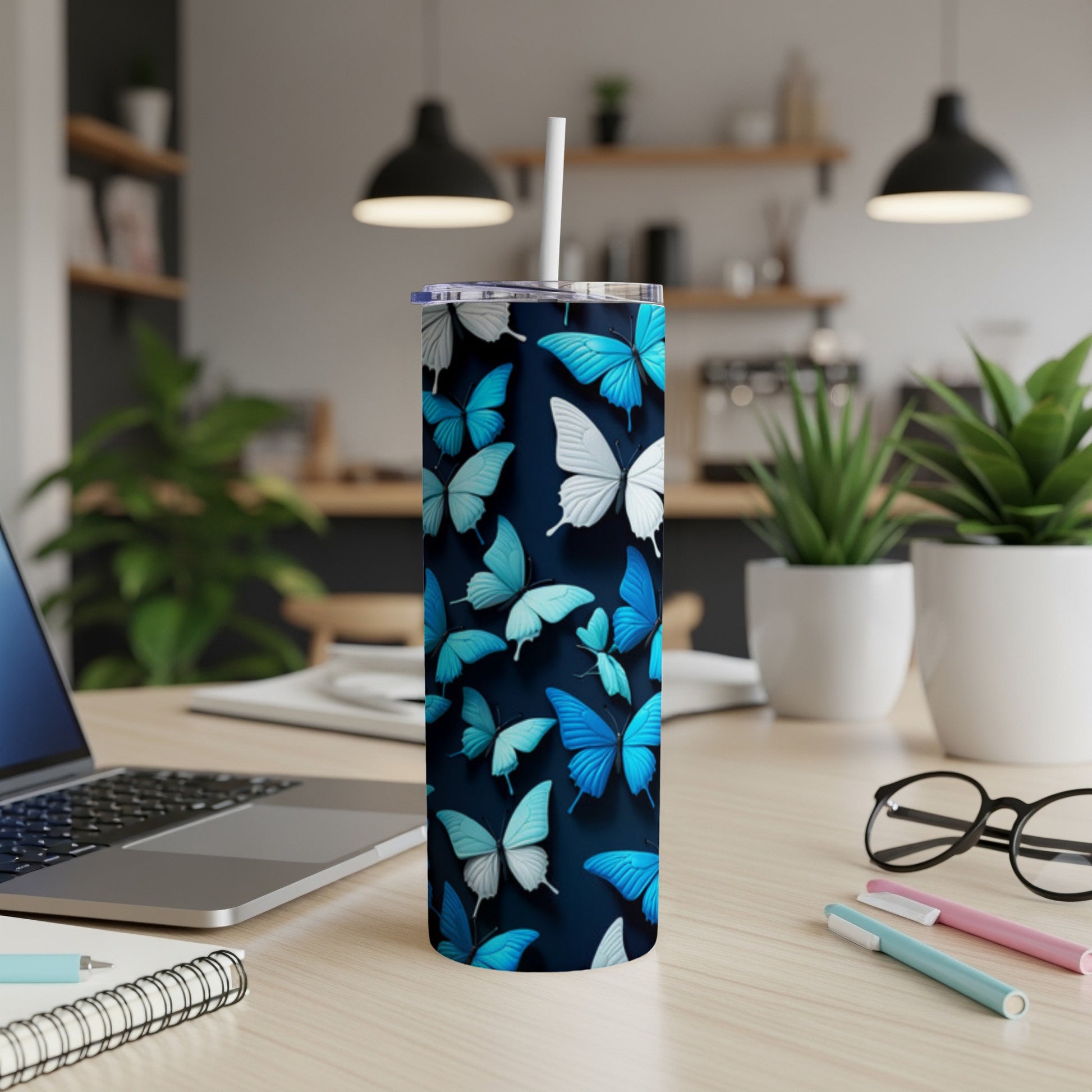 Tumbler with blue and white butterflies on a dark background.