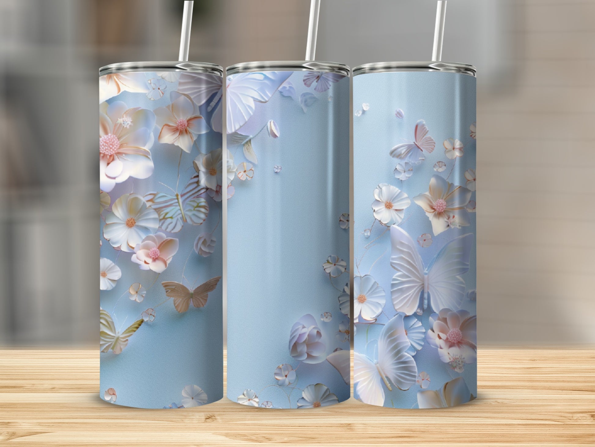 Three light blue tumblers with white and pink floral and butterfly designs.