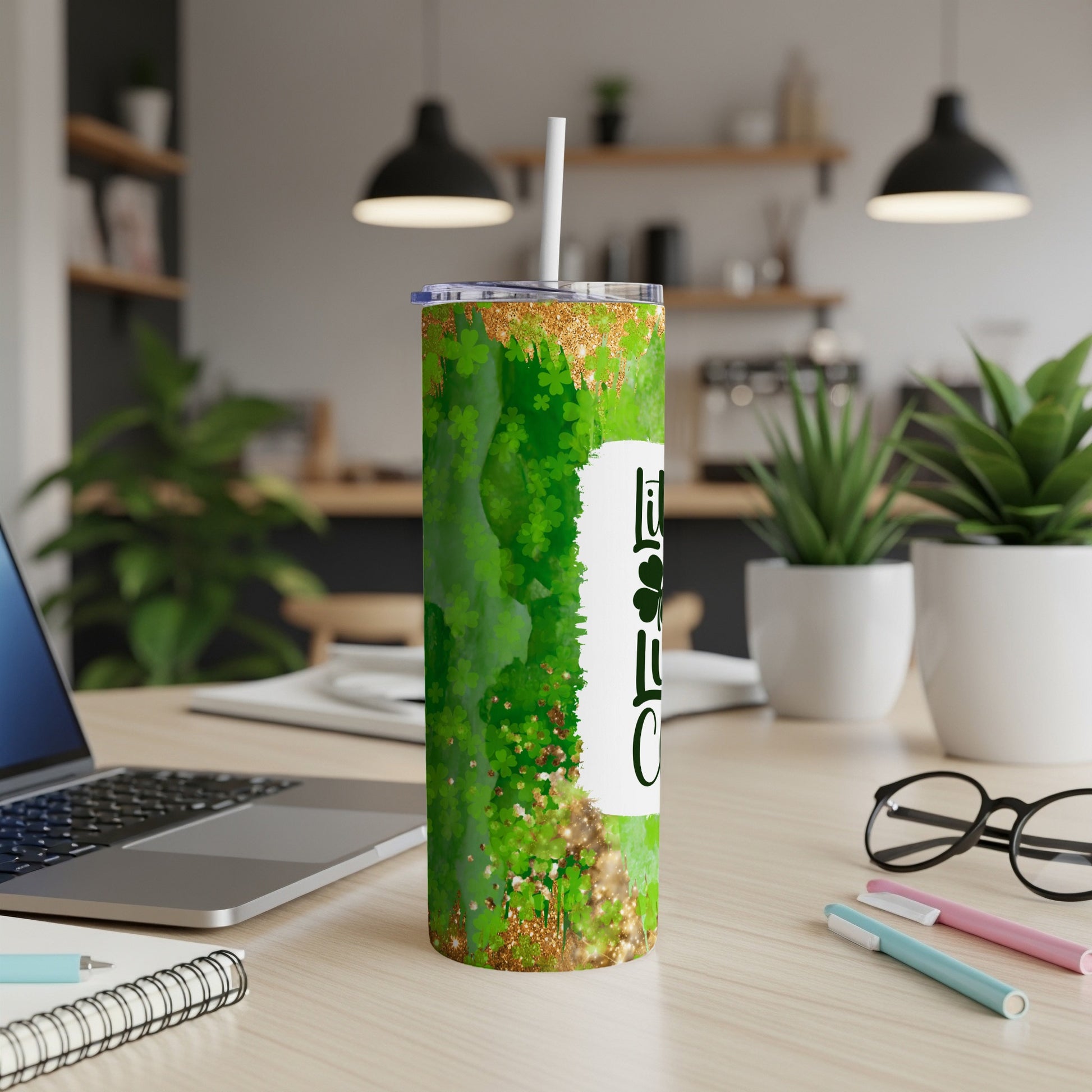 Green glitter tumbler with "Lucky Charm" text on desk.