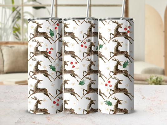 Three tumblers with a white background and falling reindeer and holly pattern.
