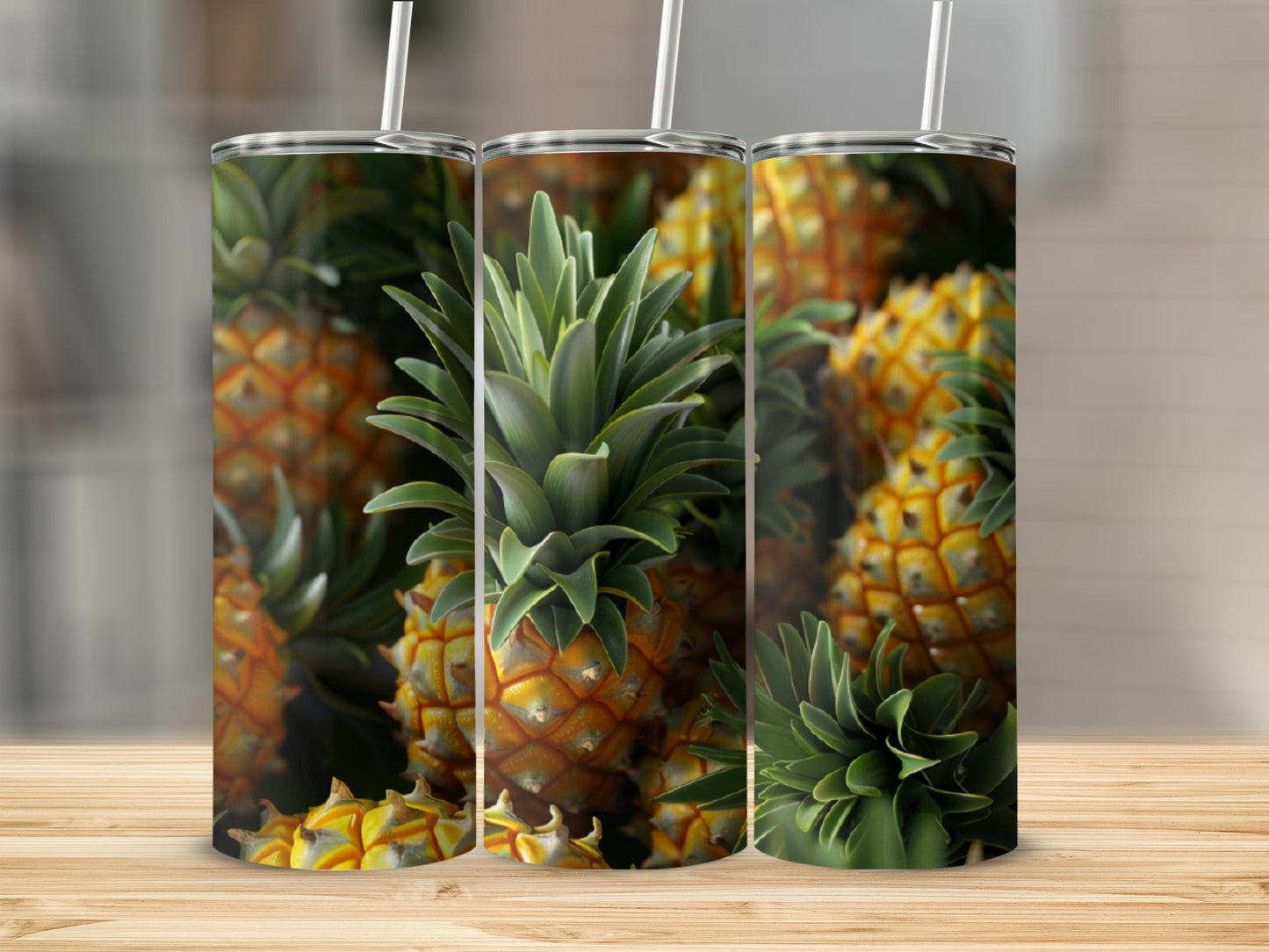Three tumblers with a pineapple pattern arranged on a wooden surface.