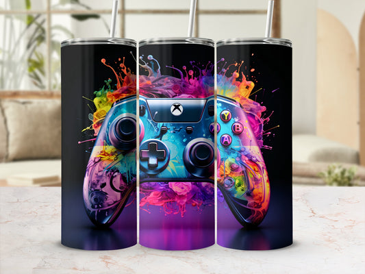 Video game controller with vibrant paint splash design, on a marble surface.