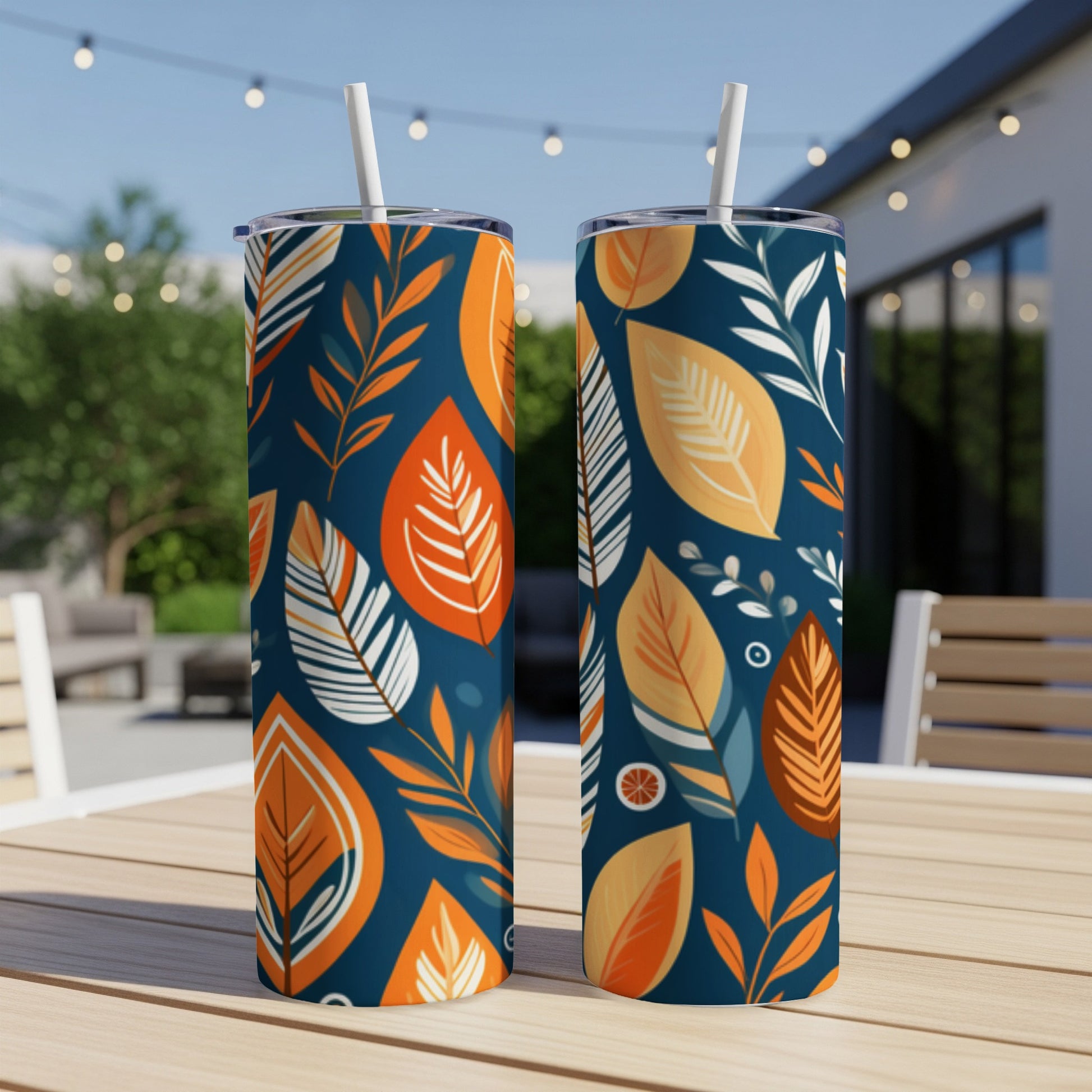 Two tall tumblers with a navy background and colorful leaf pattern.
