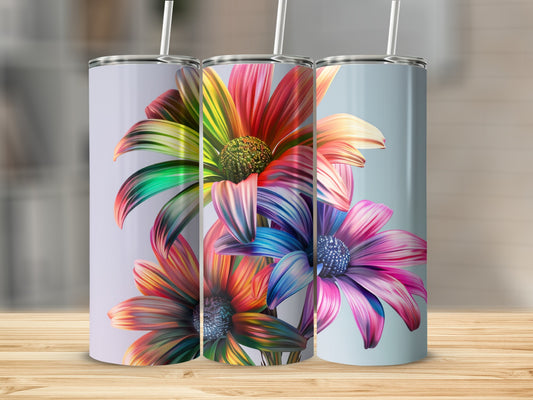 Three tall tumblers with vibrant, abstract floral designs on a wooden surface.