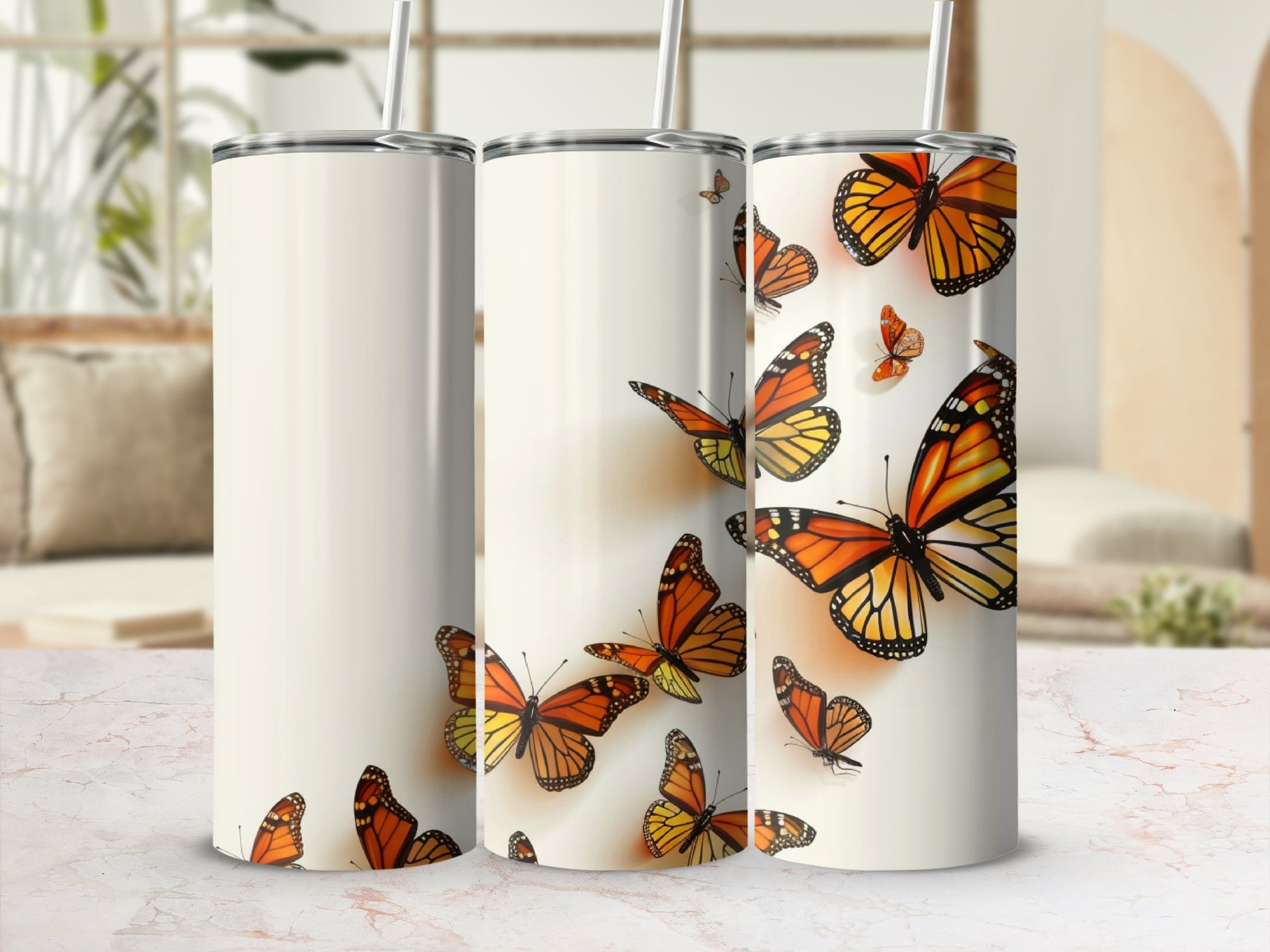 Three tumblers with orange and black monarch butterflies in flight.