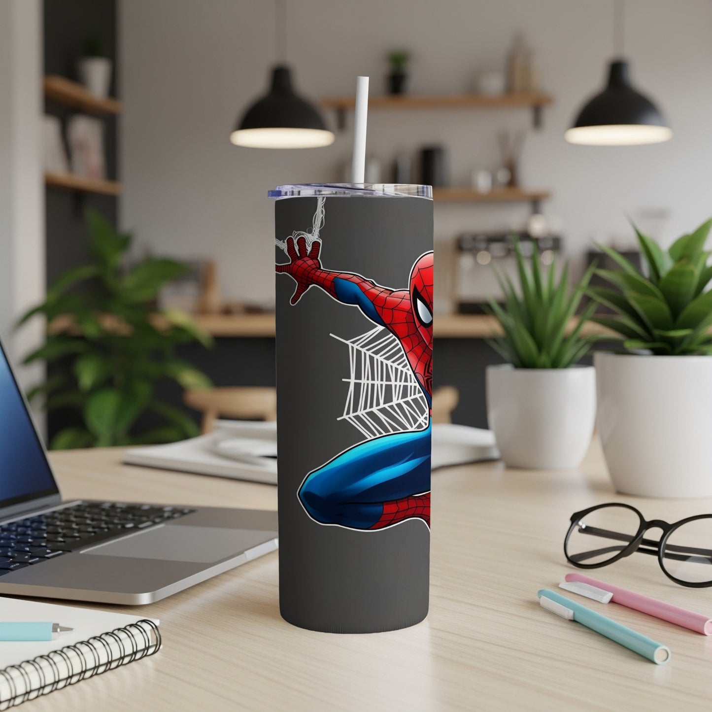 Spiderman leaping from a dark grey tumbler with a white straw.