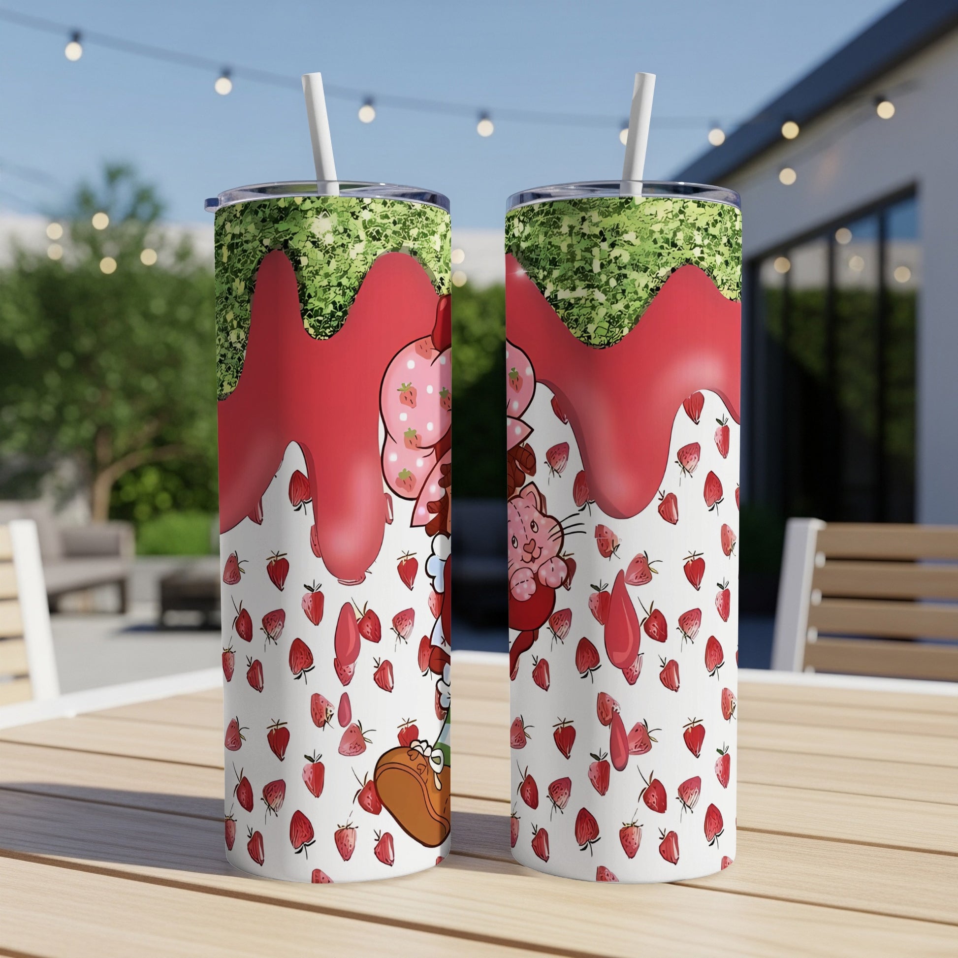Two tumblers with a strawberry, glitter, and cartoon cat design.