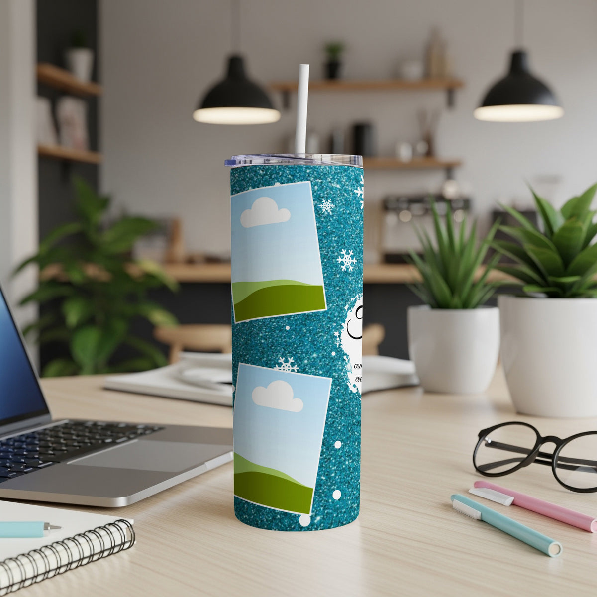Turquoise glitter tumbler with snow, clouds, and photo frames on a desk.