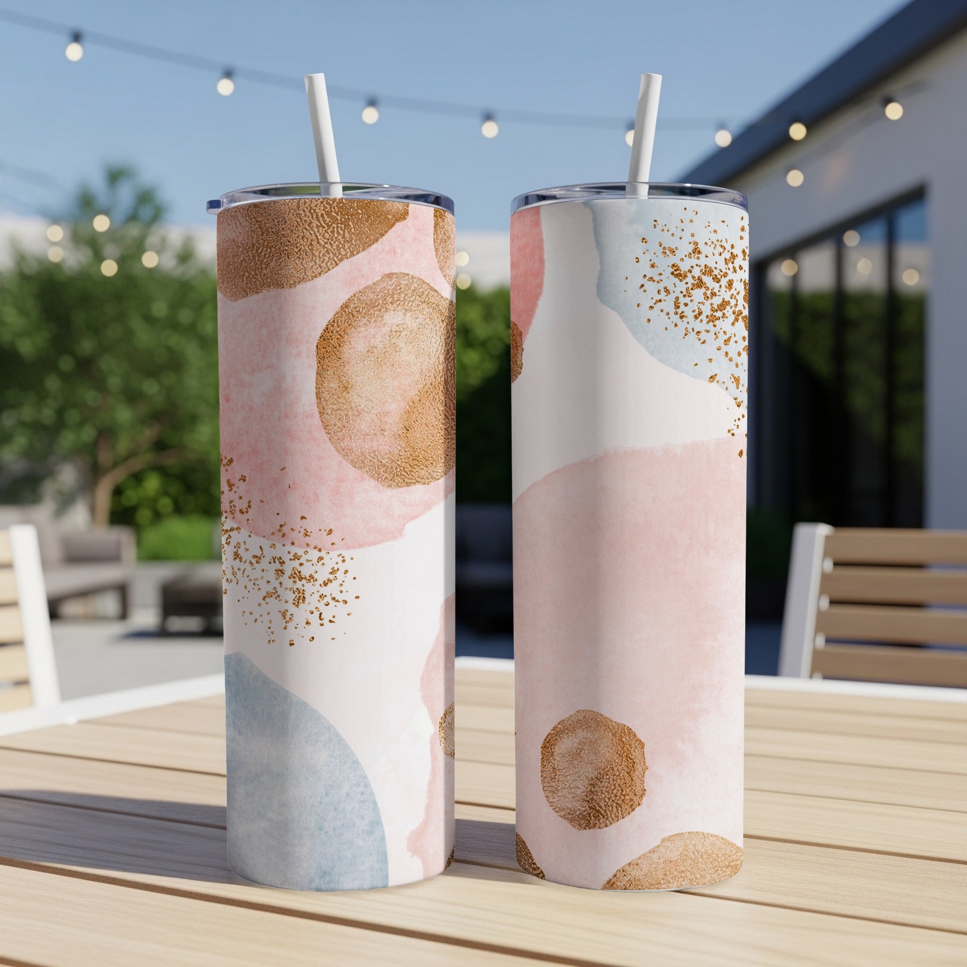 Two tumblers with abstract pink, blue, and gold watercolor patterns.