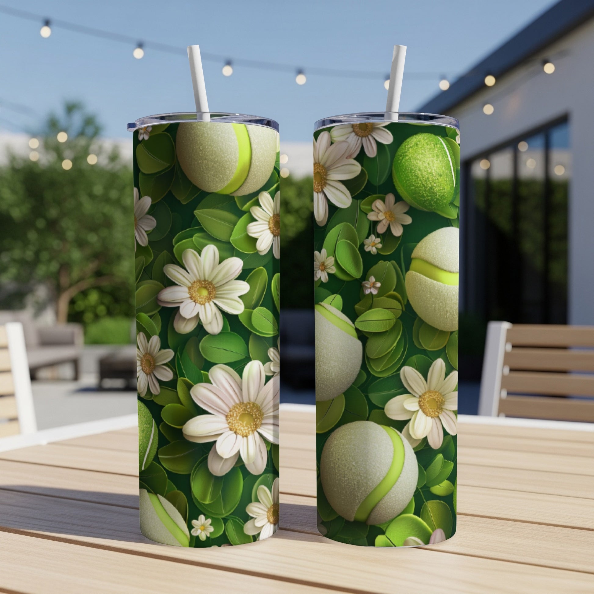Two green tennis balls with white flowers and leaves pattern on tumblers.