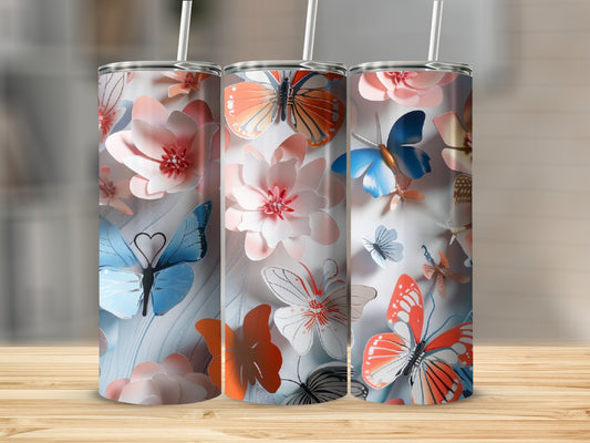 Three tumblers with floral and butterfly designs displayed on a wooden surface.
