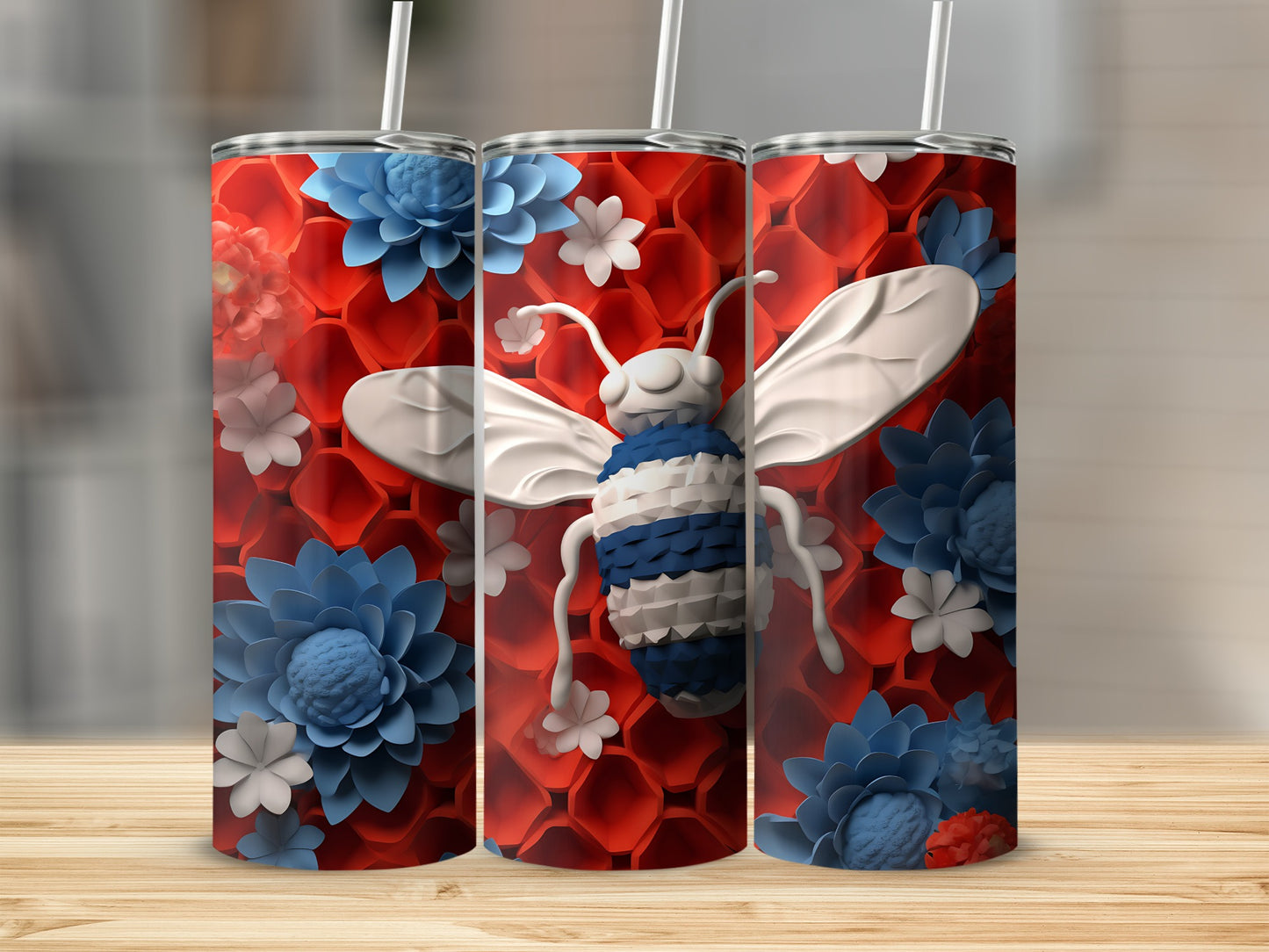 Three tumblers with bee and floral designs on a wooden surface.