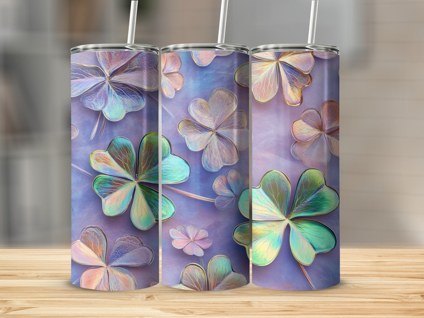 Three iridescent shamrock tumblers with straws on a wooden surface.