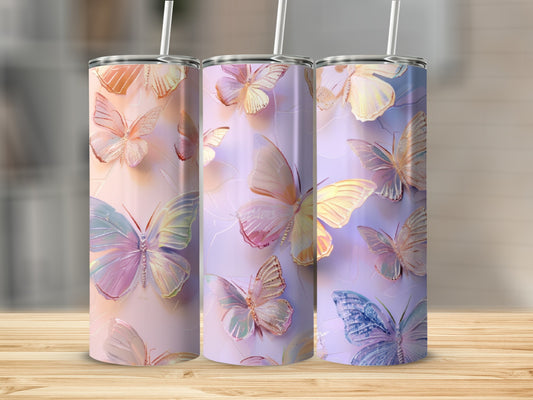 Three tumblers with iridescent butterfly designs and straws.