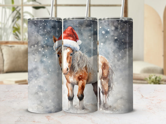 Brown and white horse wearing Santa hat in snowy scene on tumbler.