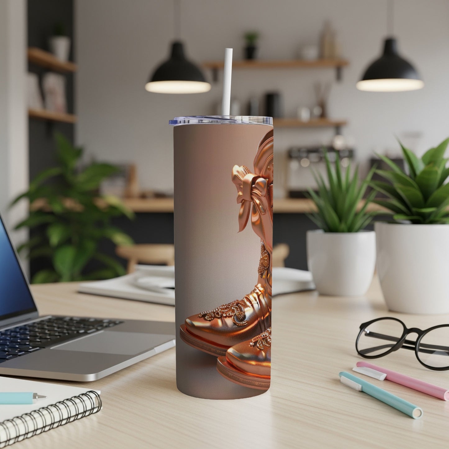 Rose gold tumbler with intricate swirling designs and a straw.
