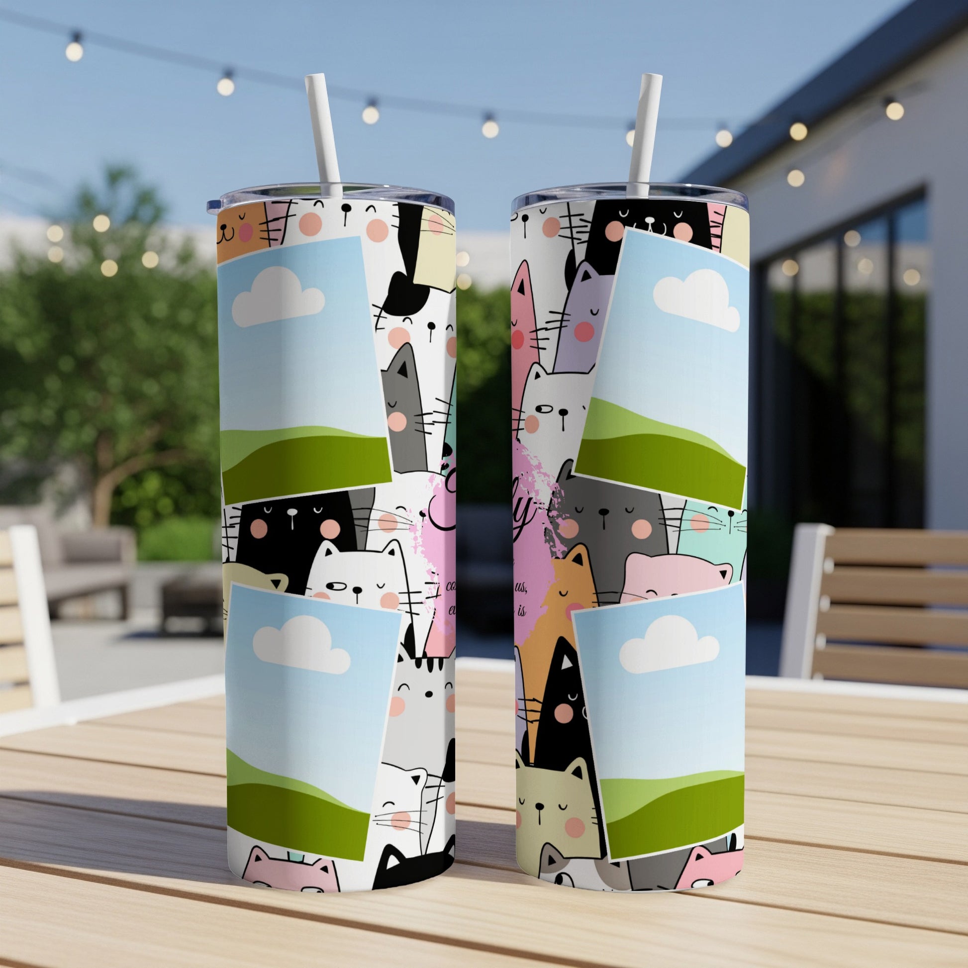 Two tall tumblers with a colorful cartoon cat collage design and straw.