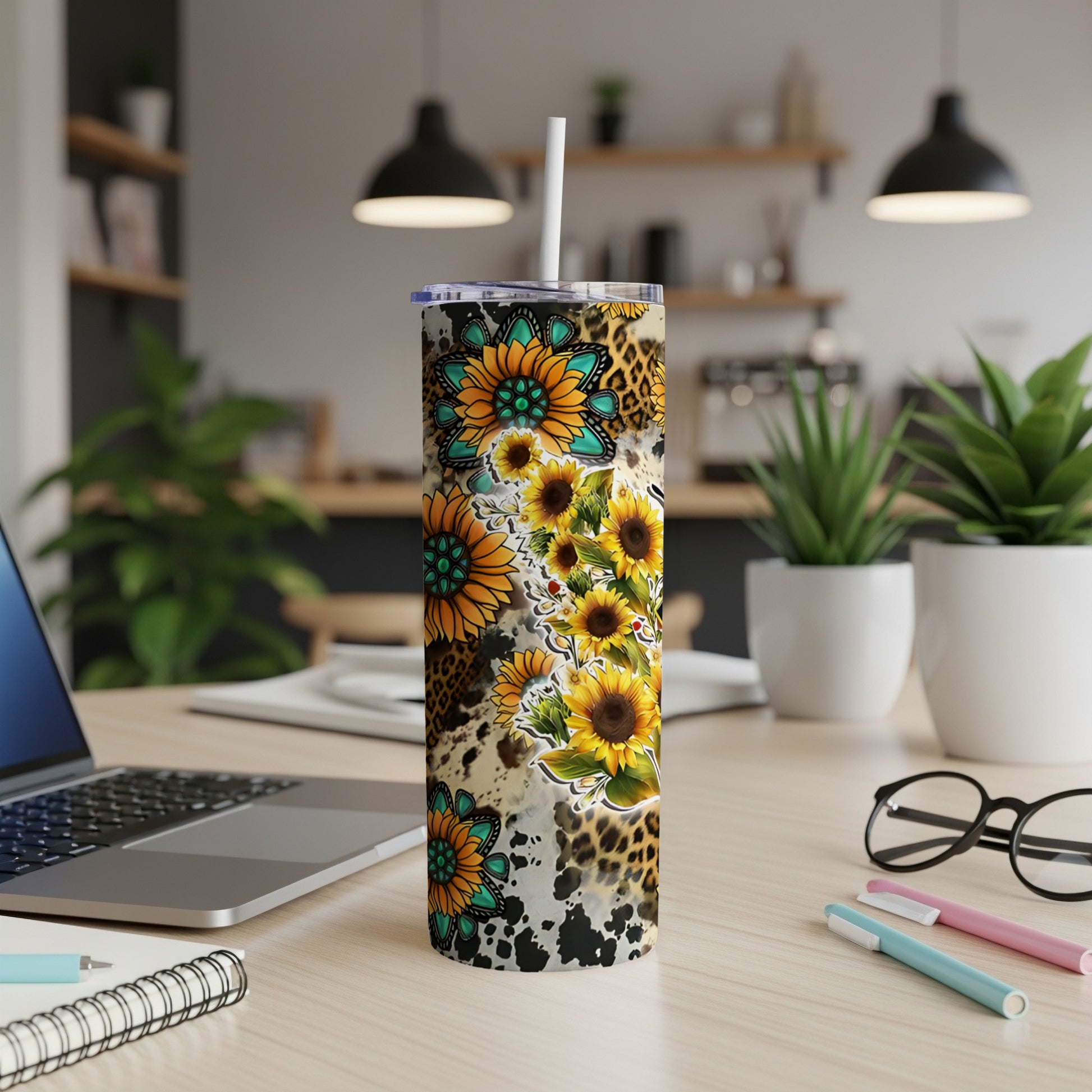 Sunflower and leopard print skinny tumbler with straw on desk.
