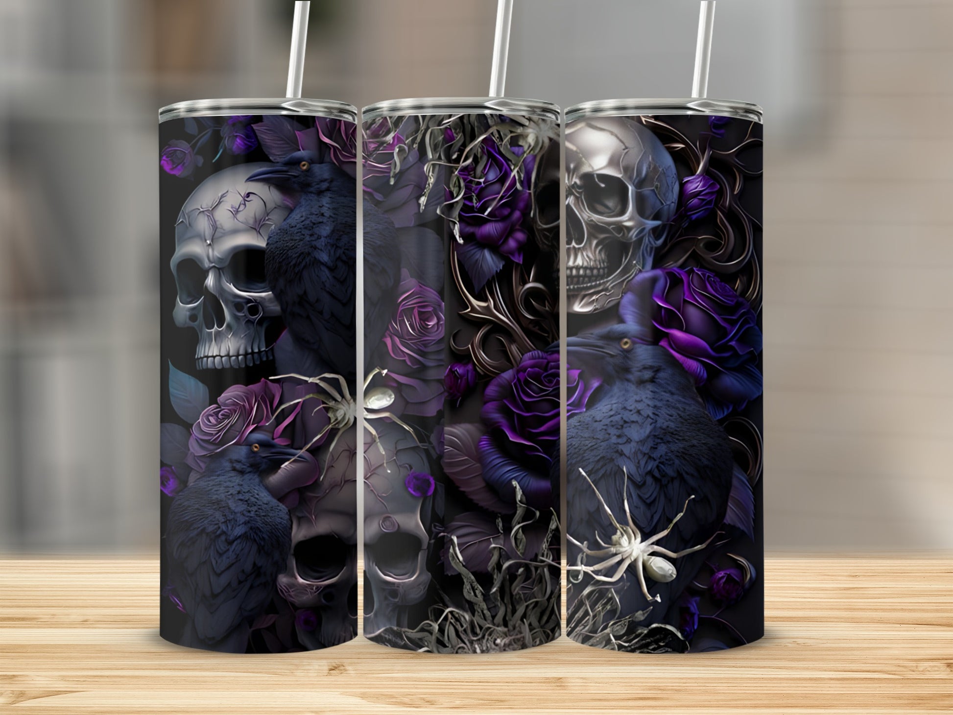 Skulls, roses, ravens, and spiders adorn three tumblers with straws on a wooden surface.