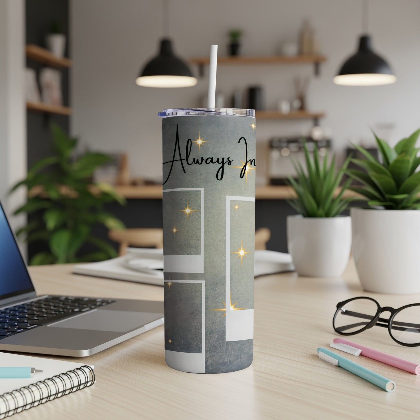 Tumbler with "Always In" text and star accents on a desk.
