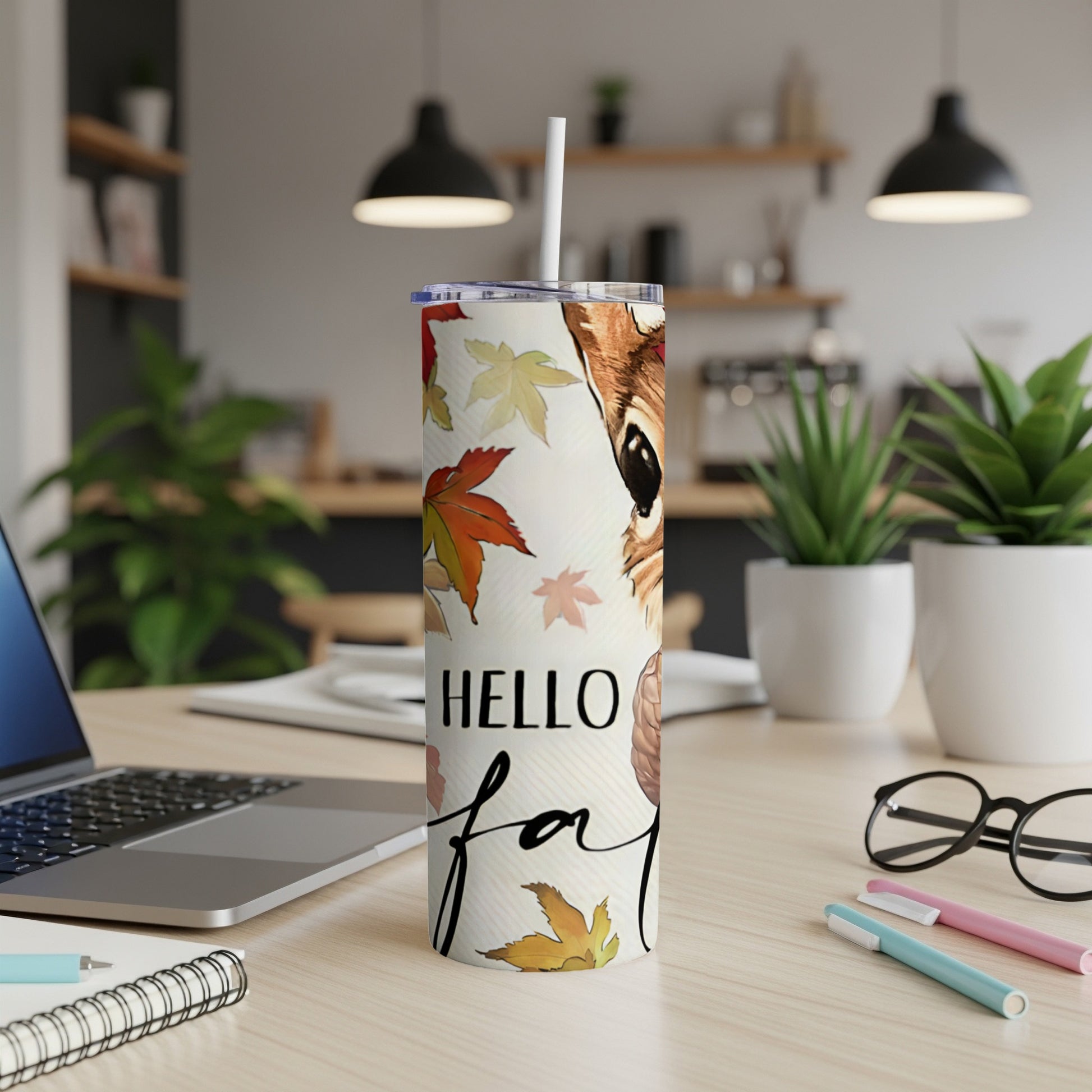 White tumbler with deer and "Hello Fall" text surrounded by autumn leaves.