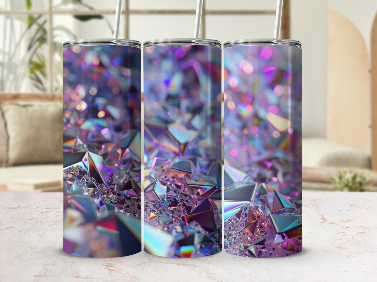 Three iridescent, faceted tumblers with straws on a speckled countertop.