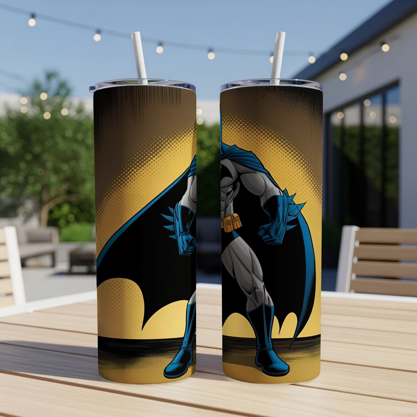 Batman comic art tumbler with straws on outdoor table.