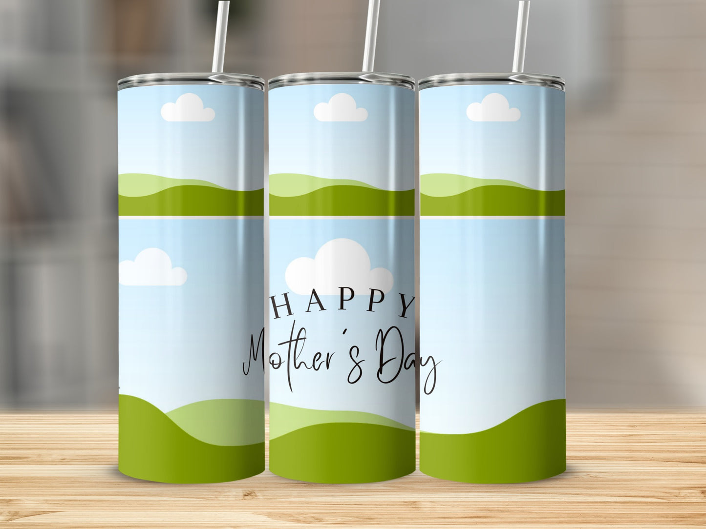 Three tumblers with a sky and rolling green hills design, one with "Happy Mother's Day" text.