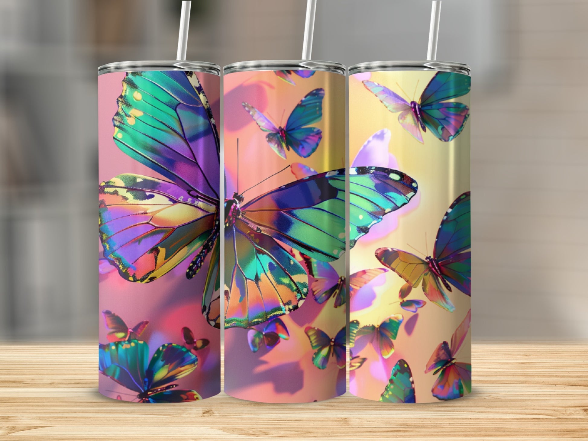 Three tumblers with iridescent butterfly designs on a wooden surface.