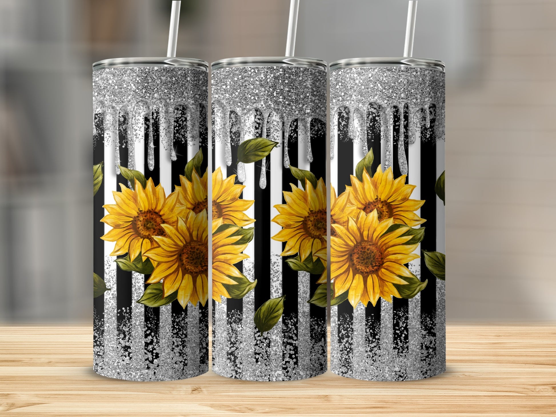 Three tumblers with sunflowers and glitter drip design on striped background.