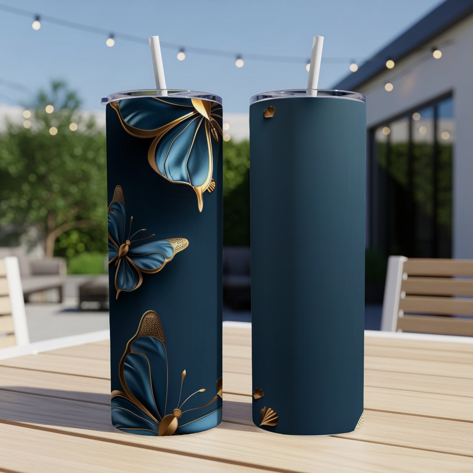 Dark blue tumblers with gold butterflies on a patio table.