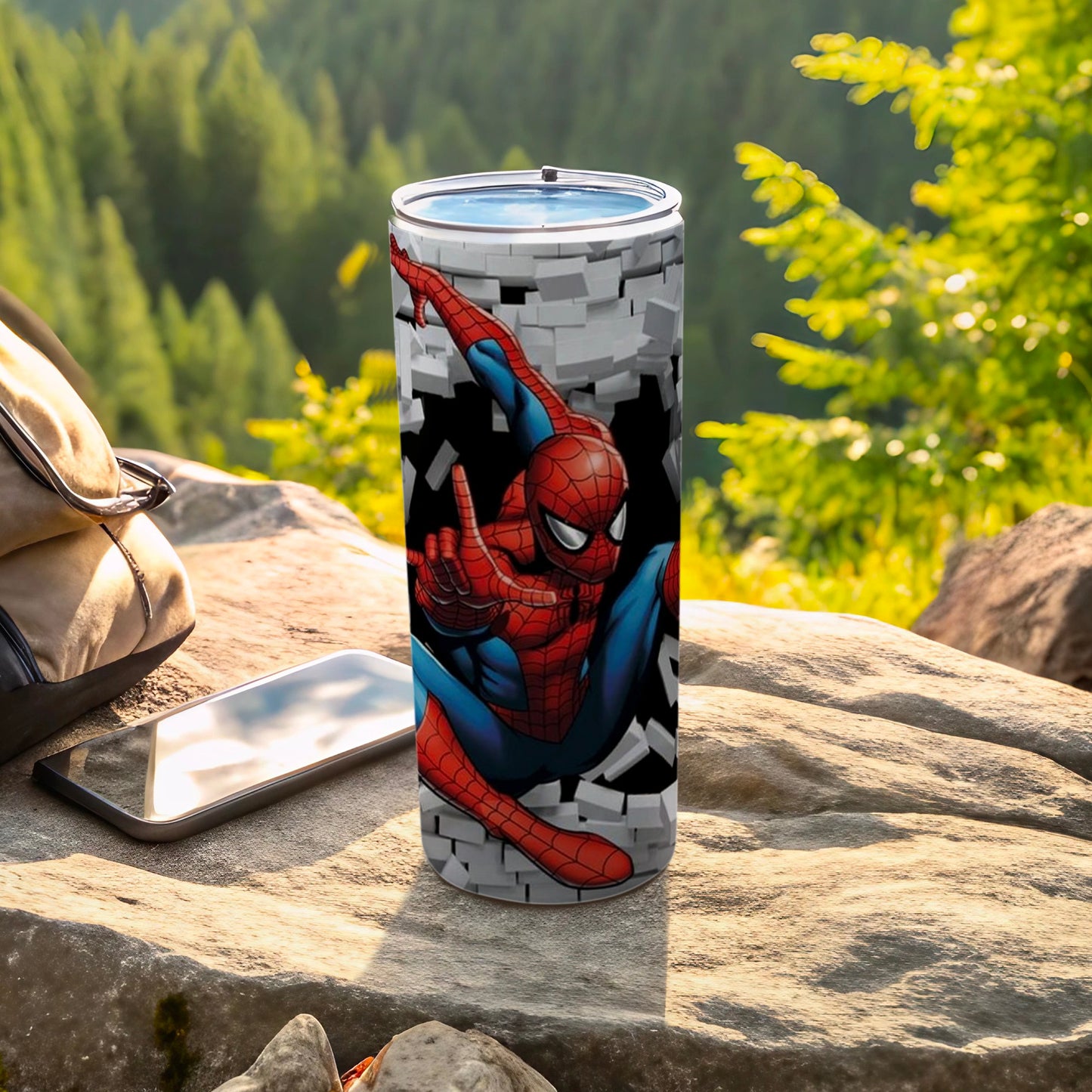 Spiderman tumbler with brick wall design, outdoors on rocks.