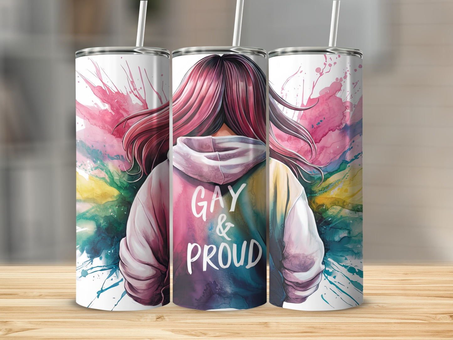 Tumbler with watercolor splash and "GAY & PROUD" text on hoodie.