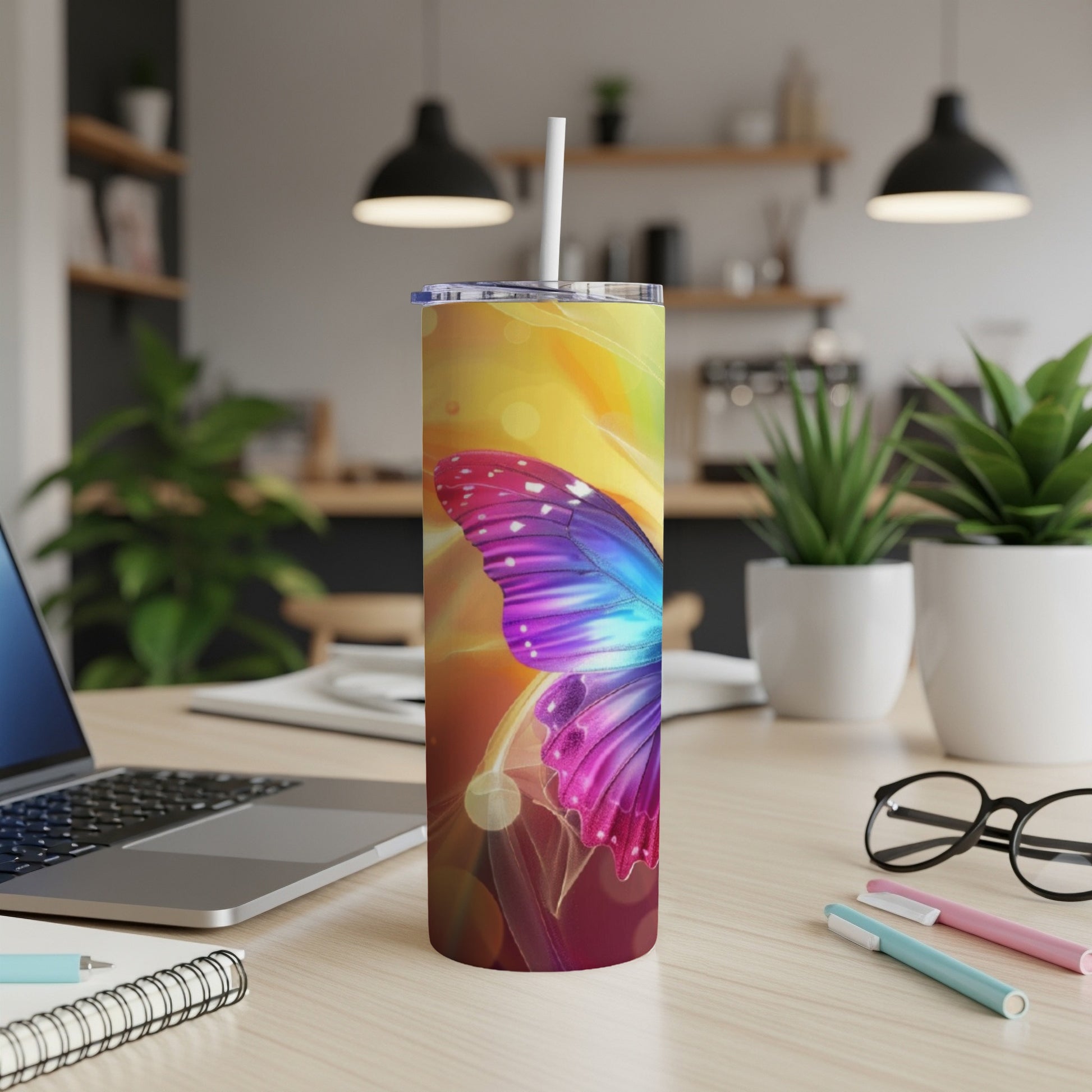 Tumbler with a colorful butterfly design on a desk.