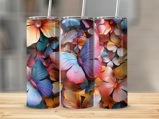 Three tumblers with colorful butterfly and floral designs sit on a wooden surface.