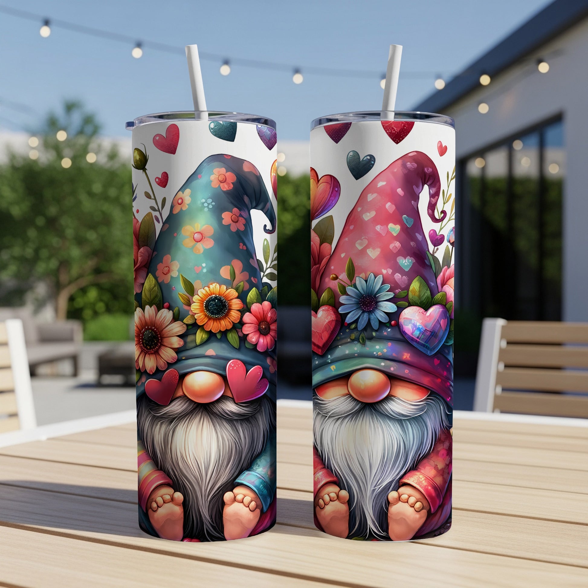 Two gnome tumblers with floral hats and heart decorations stand on a table.