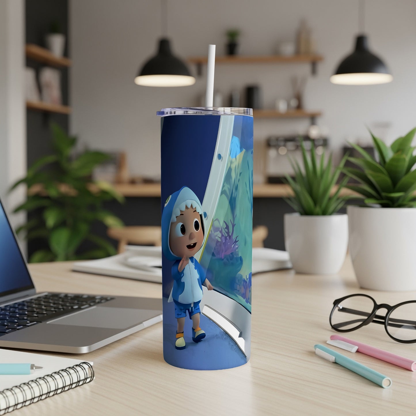 Cartoon shark boy character on a blue patterned tumbler with a straw.