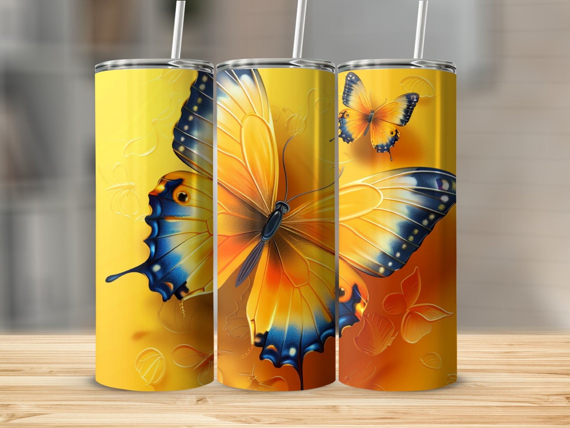 Three tumblers featuring orange, yellow, and blue butterflies with textured backgrounds.