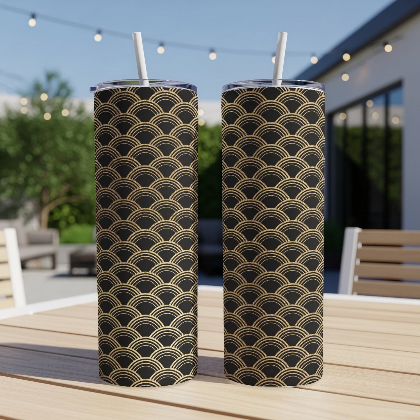 Two tumblers with black and gold Art Deco wave pattern, sitting on a table.