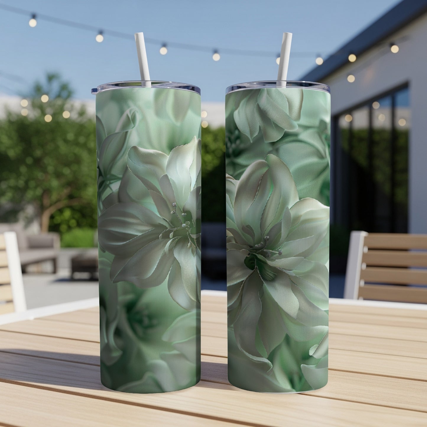 Two tumblers with pale green floral designs sit on a wooden table.