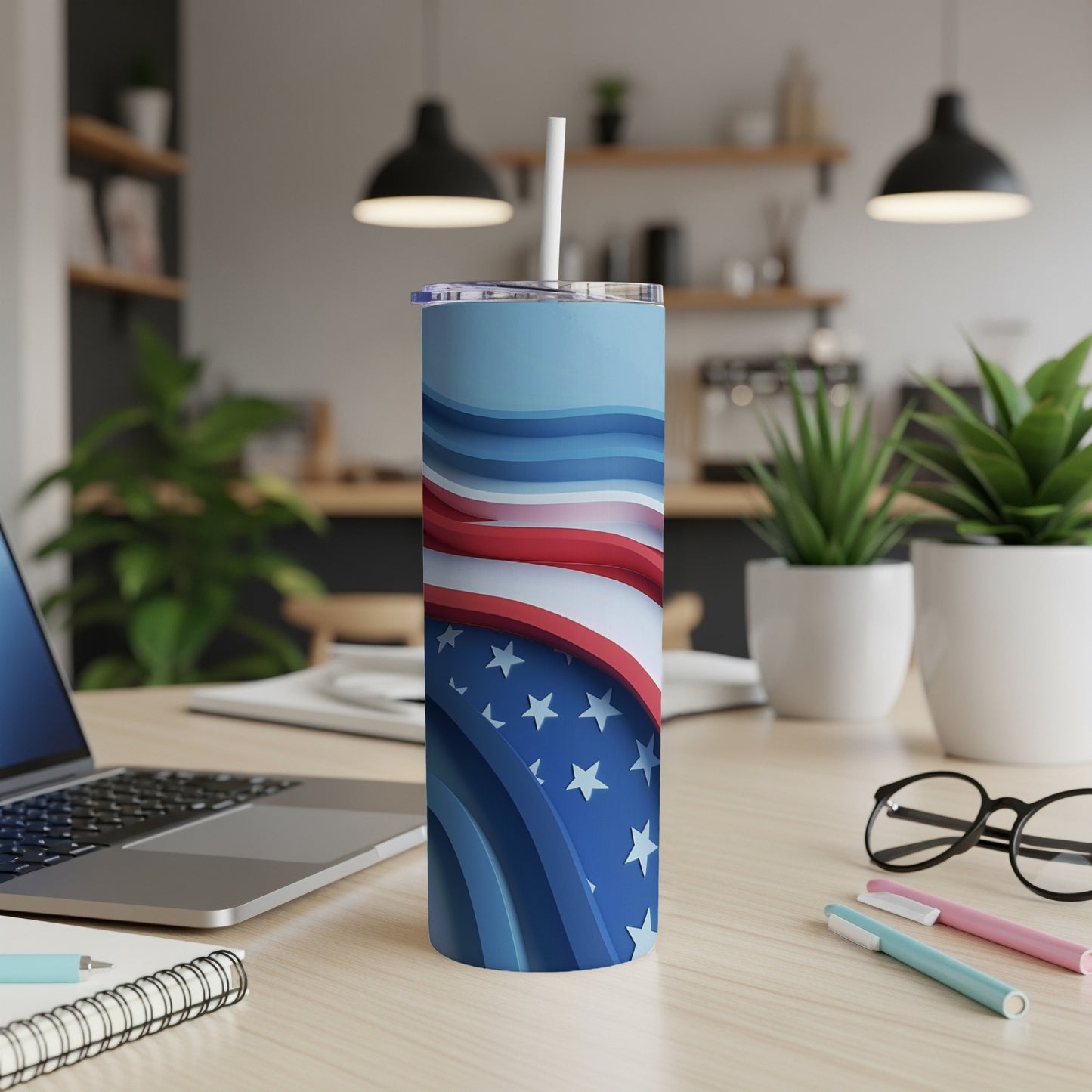 Blue and white striped tumbler with stars, on a desk.