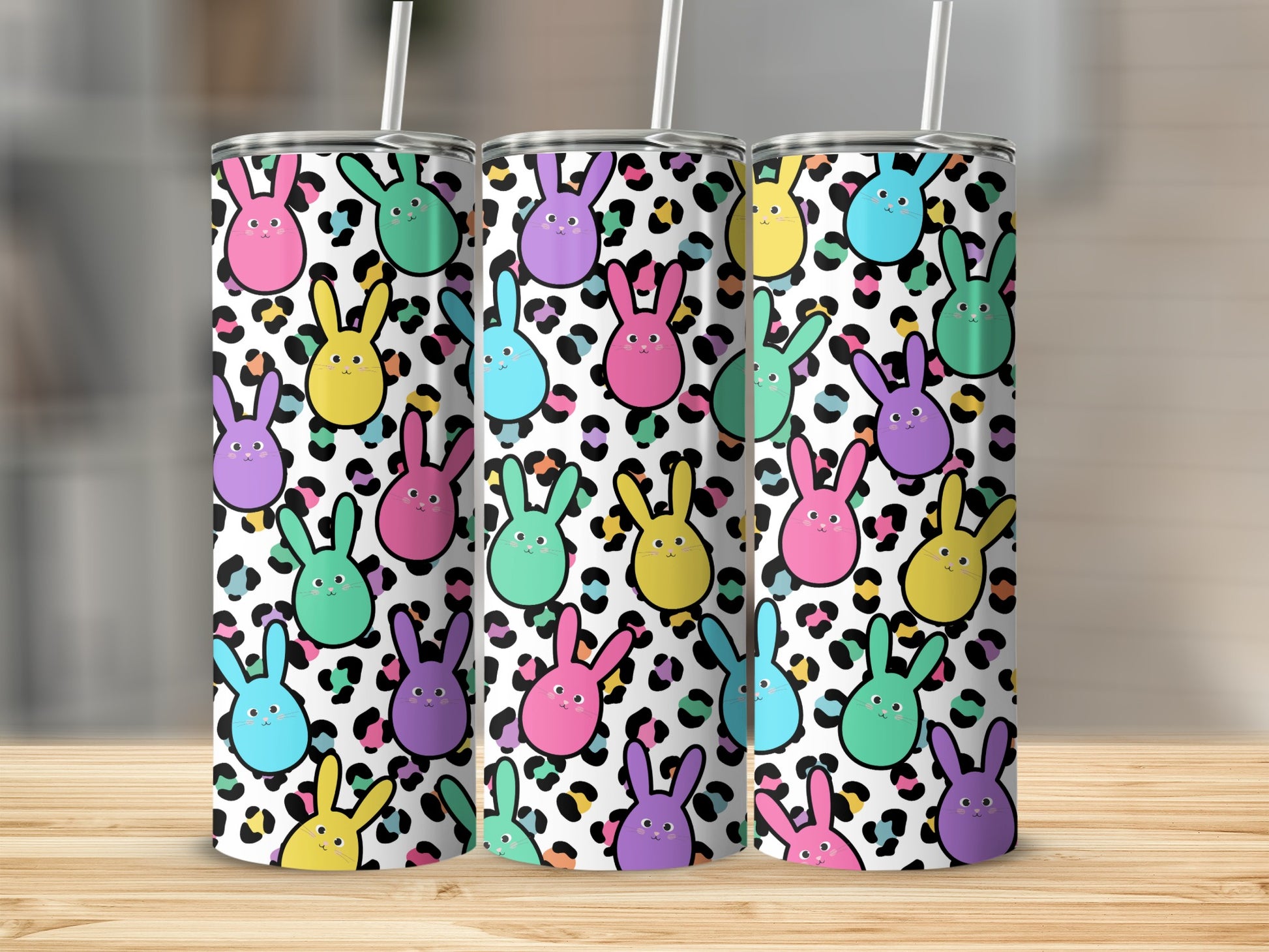 Three tall tumblers with a colorful Easter bunny and leopard print pattern.
