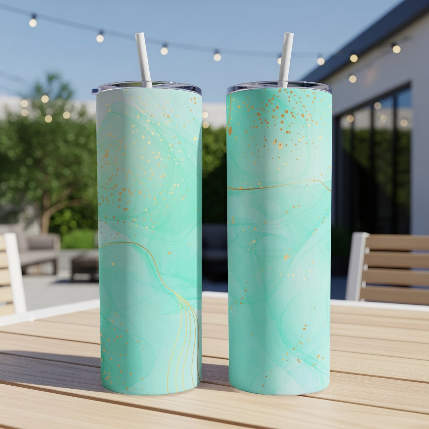 Two teal tumblers with gold abstract marbled pattern and straws.