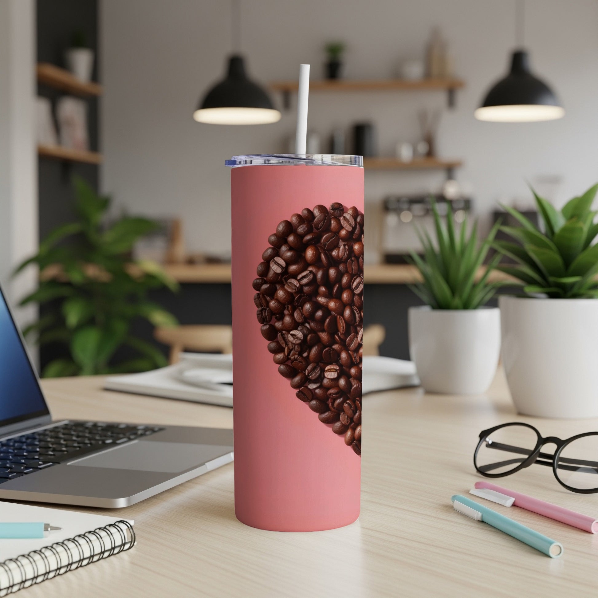 Pink tumbler with heart shape of coffee beans and straw.
