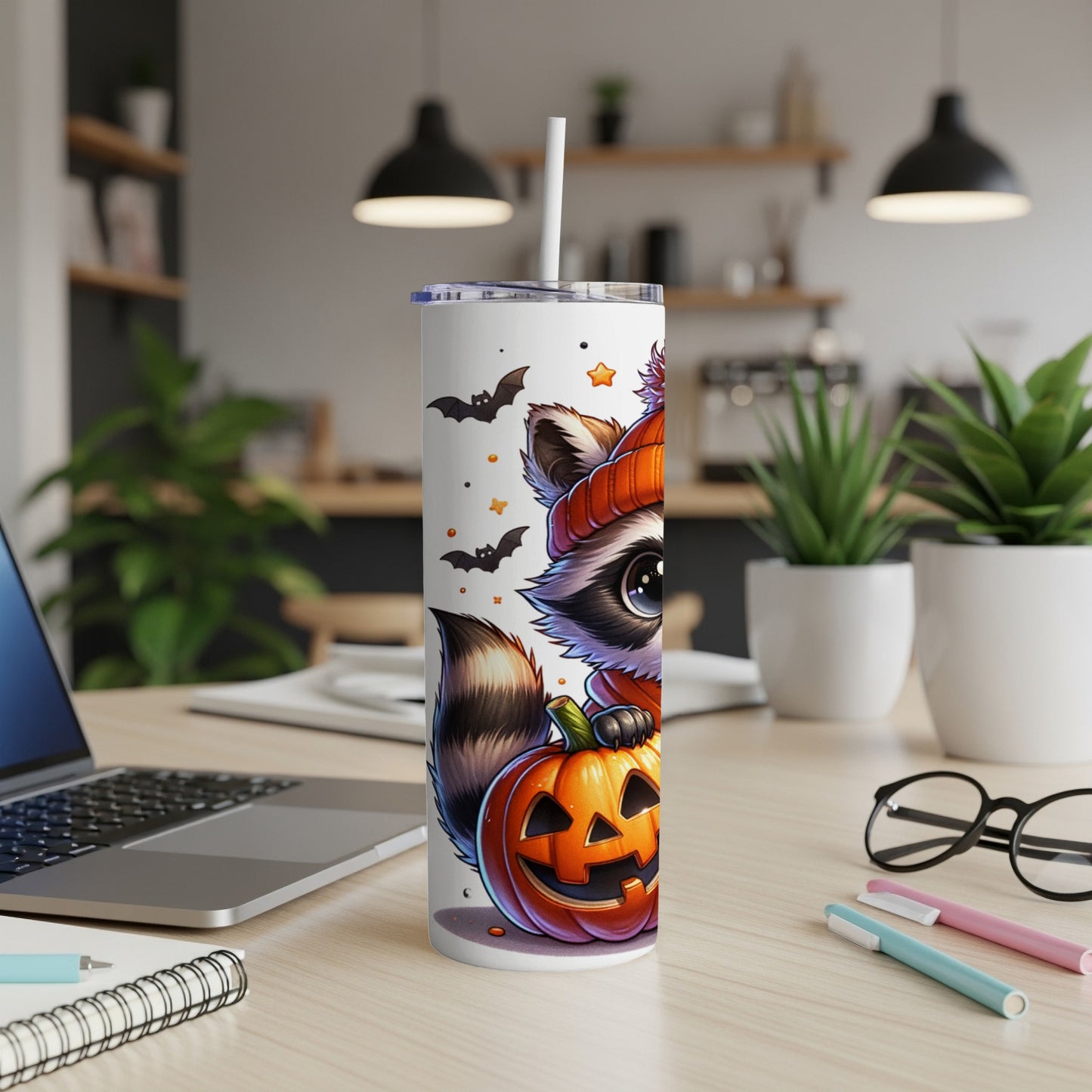 White tumbler with cute raccoon and jack-o'-lantern Halloween design.
