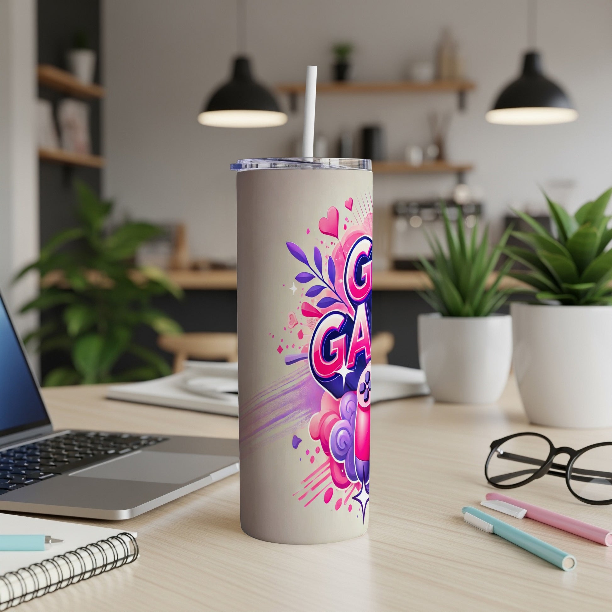 Cream tumbler with colorful "Gamer" text and hearts, on a desk.