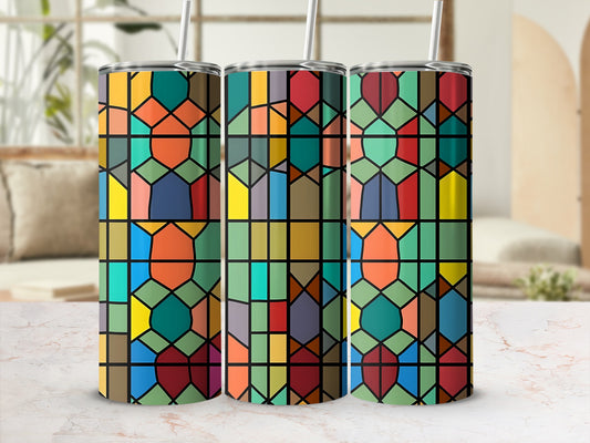 Three stained glass patterned tumblers with straws stand on a marbled surface.
