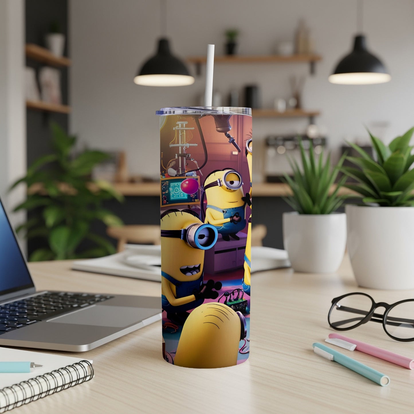 Minions illustration on a tall tumbler with a straw on a desk.