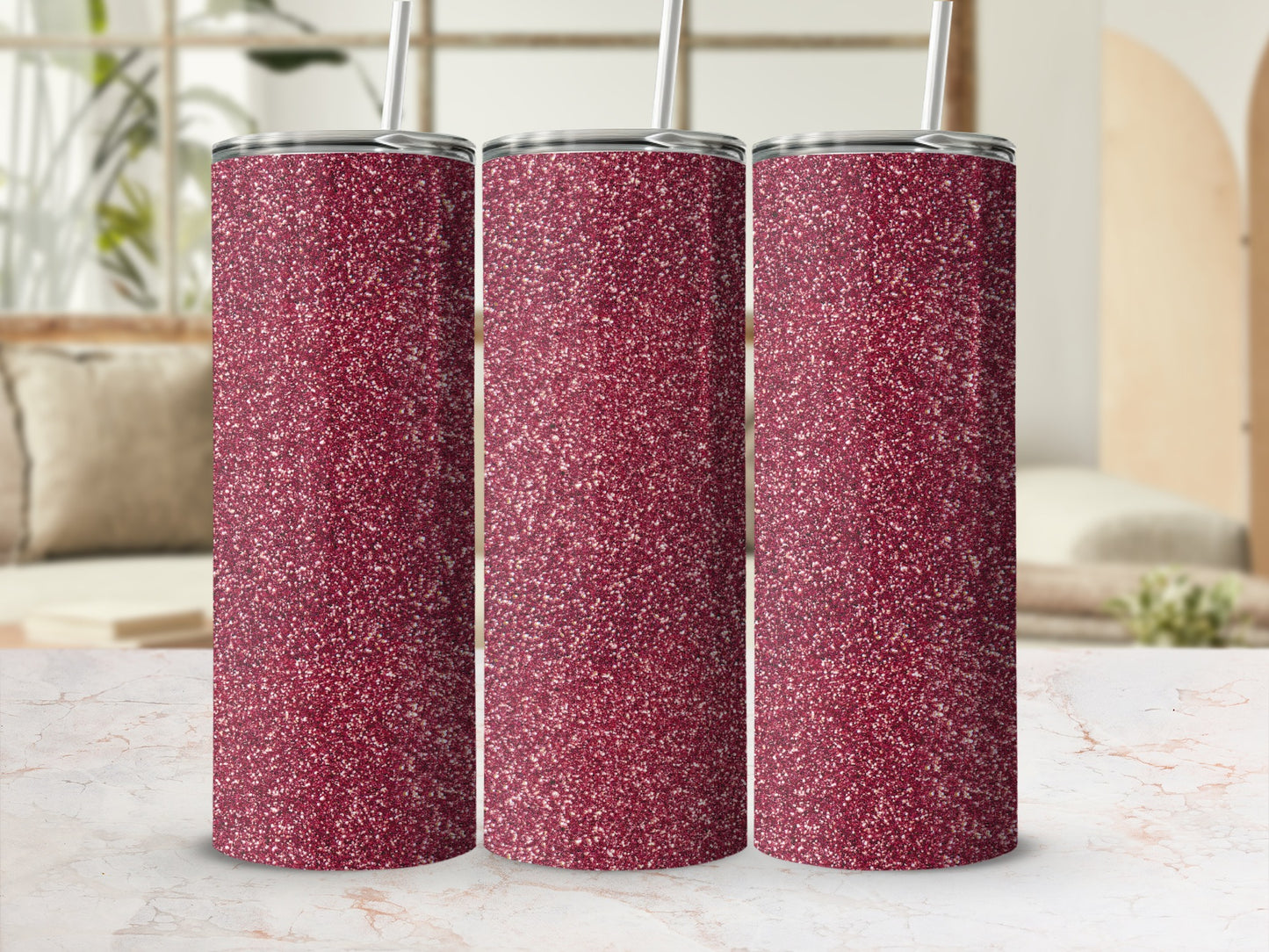 Three glittery crimson tumblers with straws stand in a row.