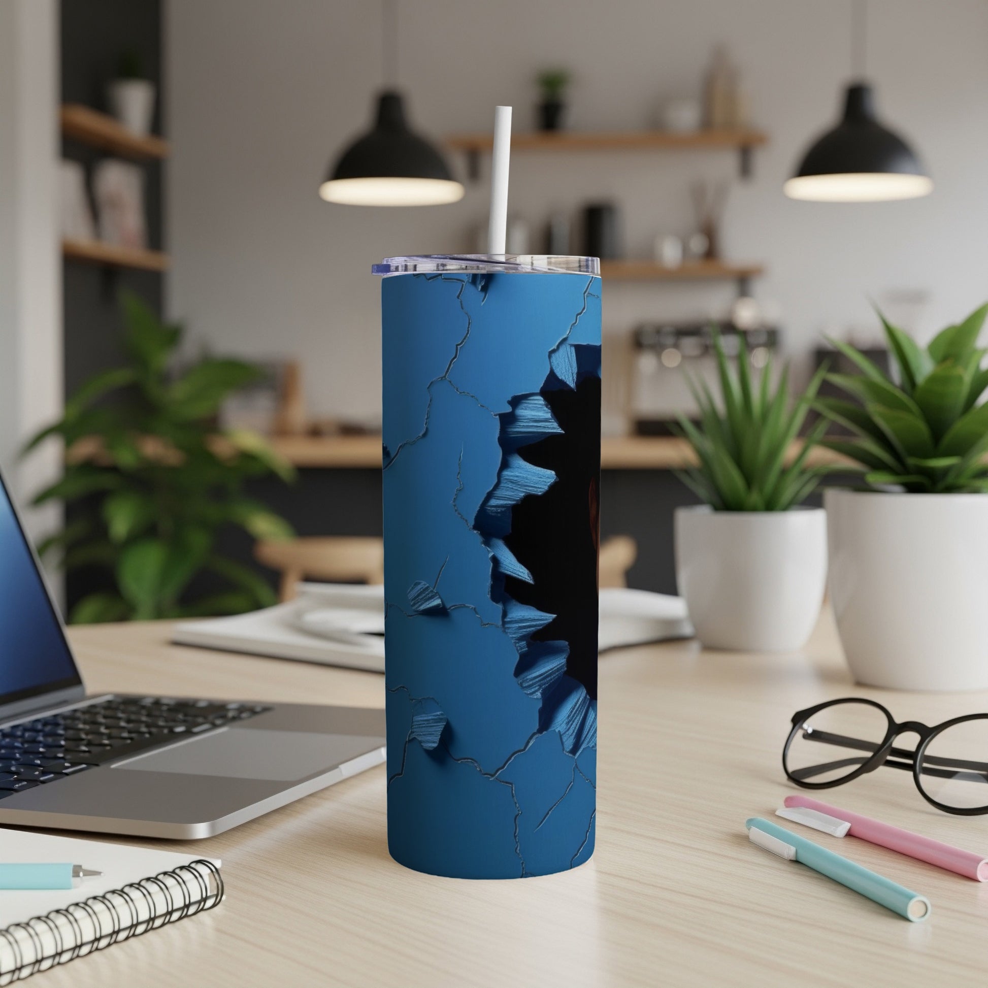 Blue cracked texture tumbler with a straw, on a desk with a laptop.
